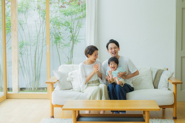 新築住宅の広いリビングでフローリング床へUVコーティングを施工する作業全景